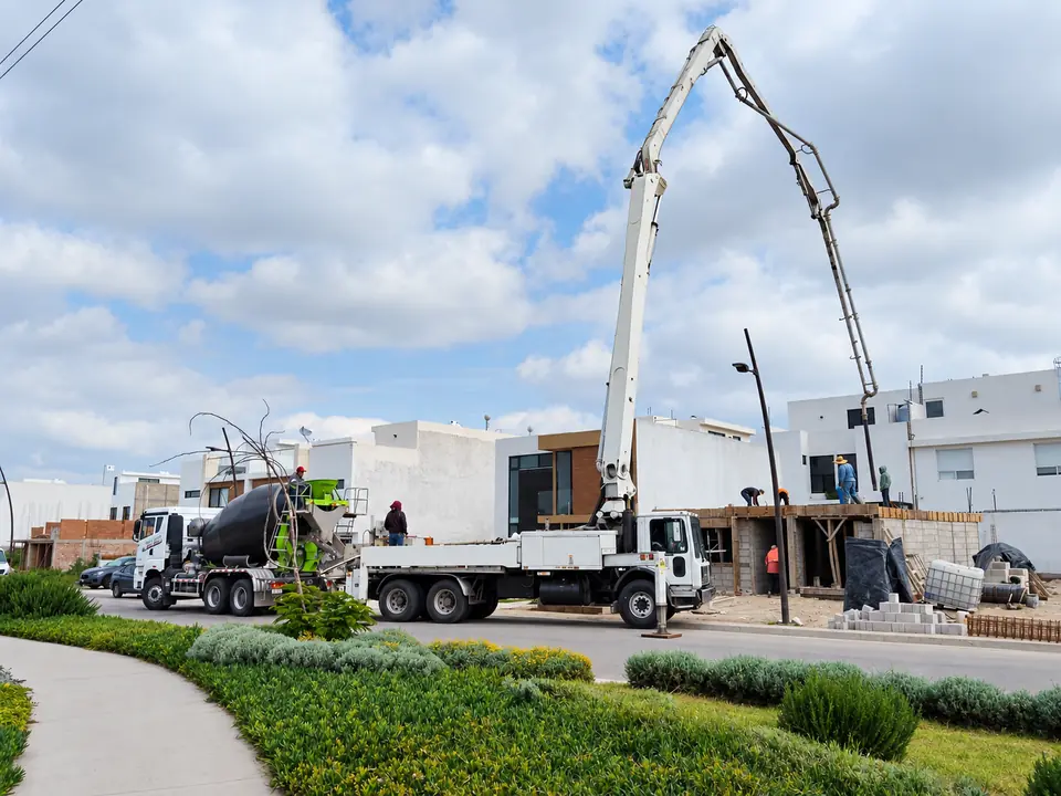 Bomba pluma de ACBSA extendida para suministrar concreto en una obra residencial